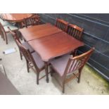 A MAHOGANY EXTENDING DINING TABLE AND SIX SPINDLE BACK DINING CHAIRS