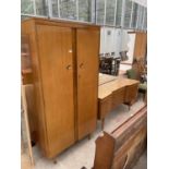 A MID 20TH CENTURY WALNUT DRESSING TABLE AND WARDROBE ON TAPERING LEGS