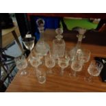 THREE GLASS DECANTERS WITH WITH LIDS AND AN ASSORTMENT OF GLASSES
