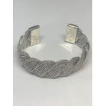 A HEAVY SILVER BRACELET WITH A TWIST DESIGN