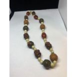 AN AMBER AND CARVED NUT ORIENTAL STYLE NECKLACE