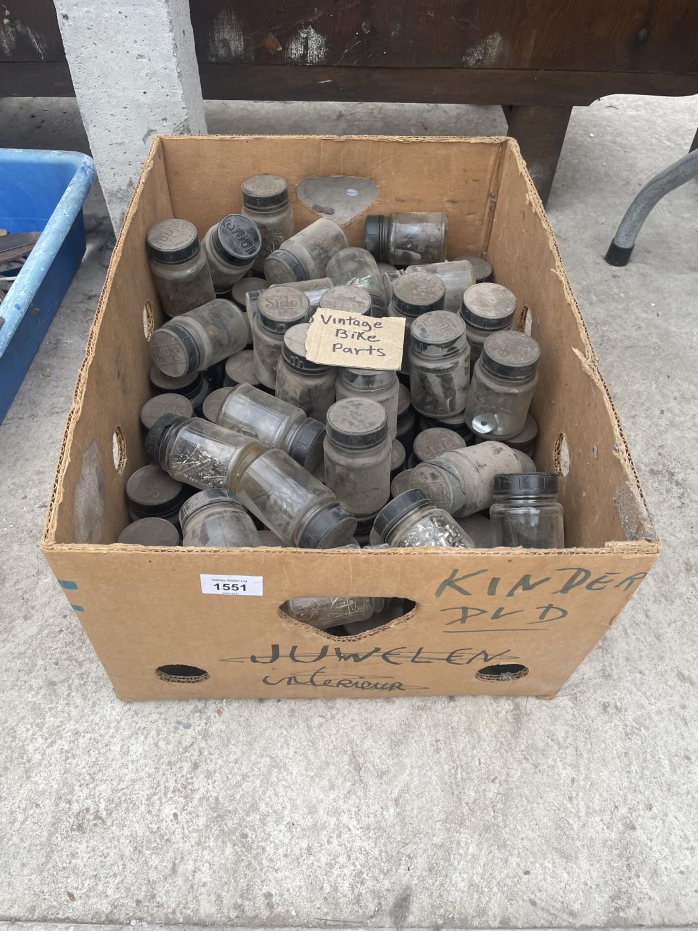 A LARGE QUANTITY OF GLASS JARS CONTAINING HARDWARE AND BIKE PARTS ETC