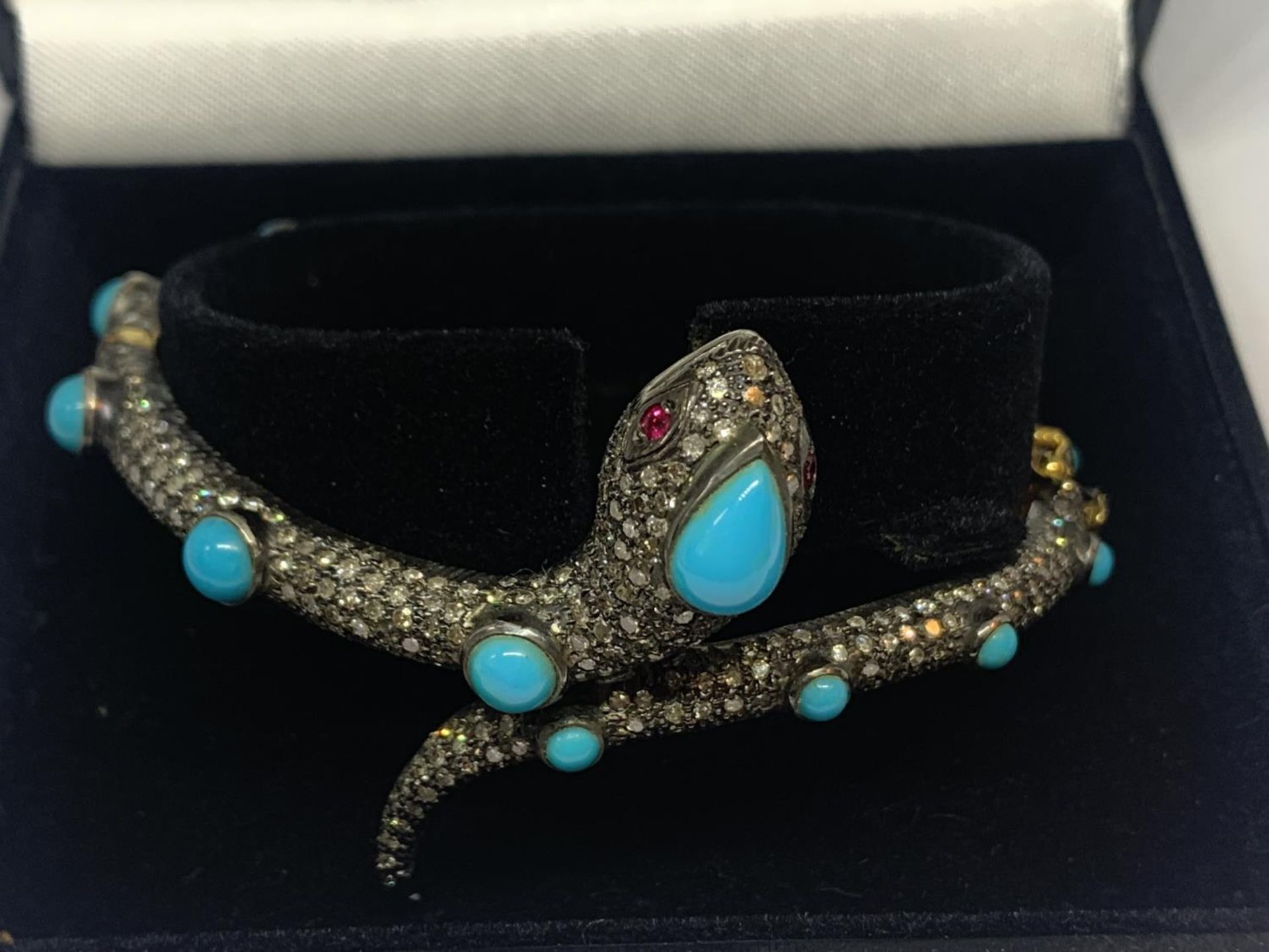 A GOLD AND WHITE GOLD SNAKE BANGLE ENCRUSTED WITH DIAMONDS, RUBY EYES AND BLUE NAJAVO STONES - Image 4 of 10