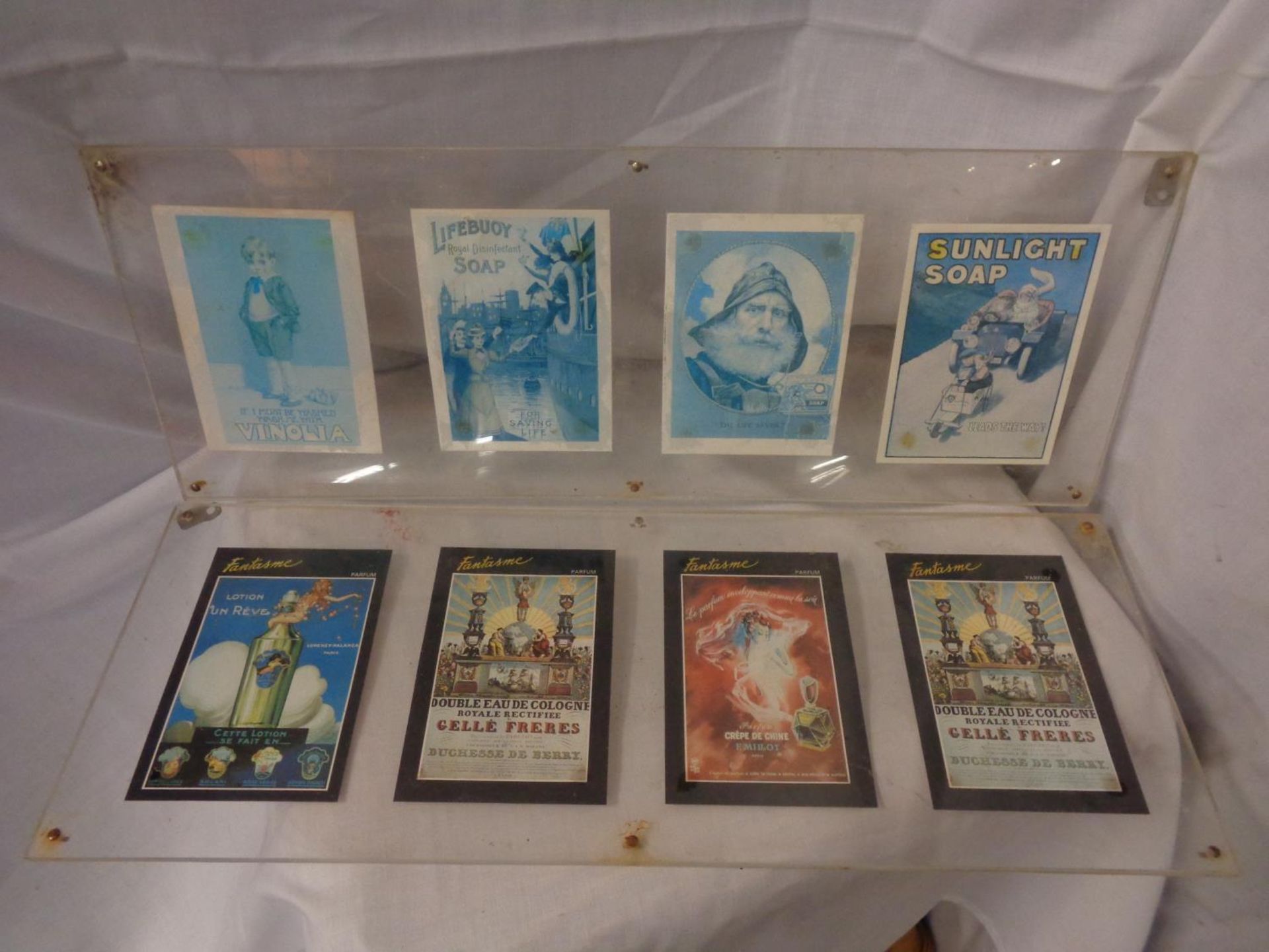 A VARIETY OF FRAMED SOAP AND PERFUME POSTCARDS