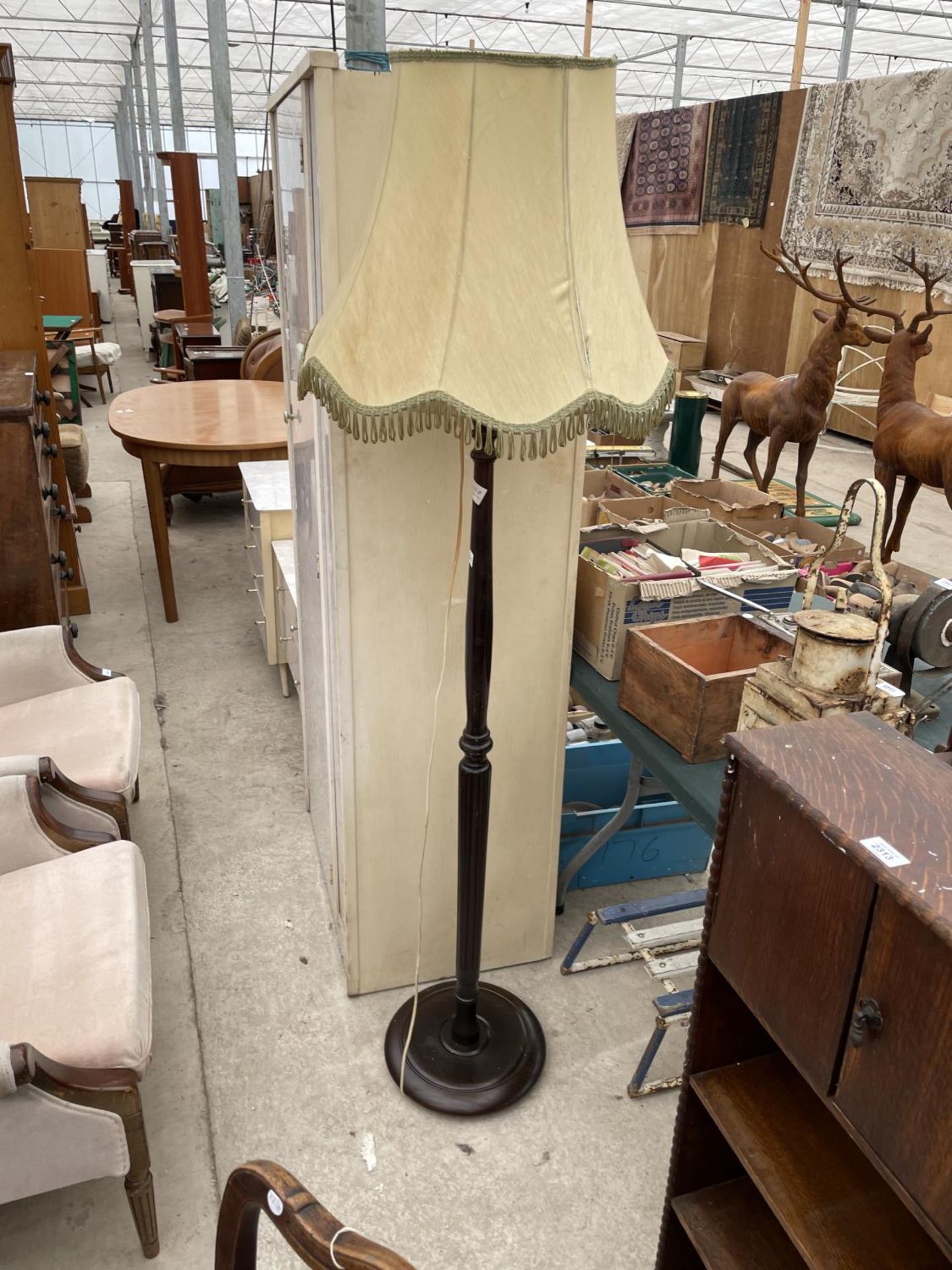 A 20TH CENTURY TURNED AND FLUTED STANDARD LAMP COMPLETE WITH SHADE