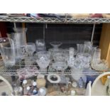 A LARGE ASSORTMENT OF GLASS WARE TO INCLUDE BOWLS AND VASES ETC