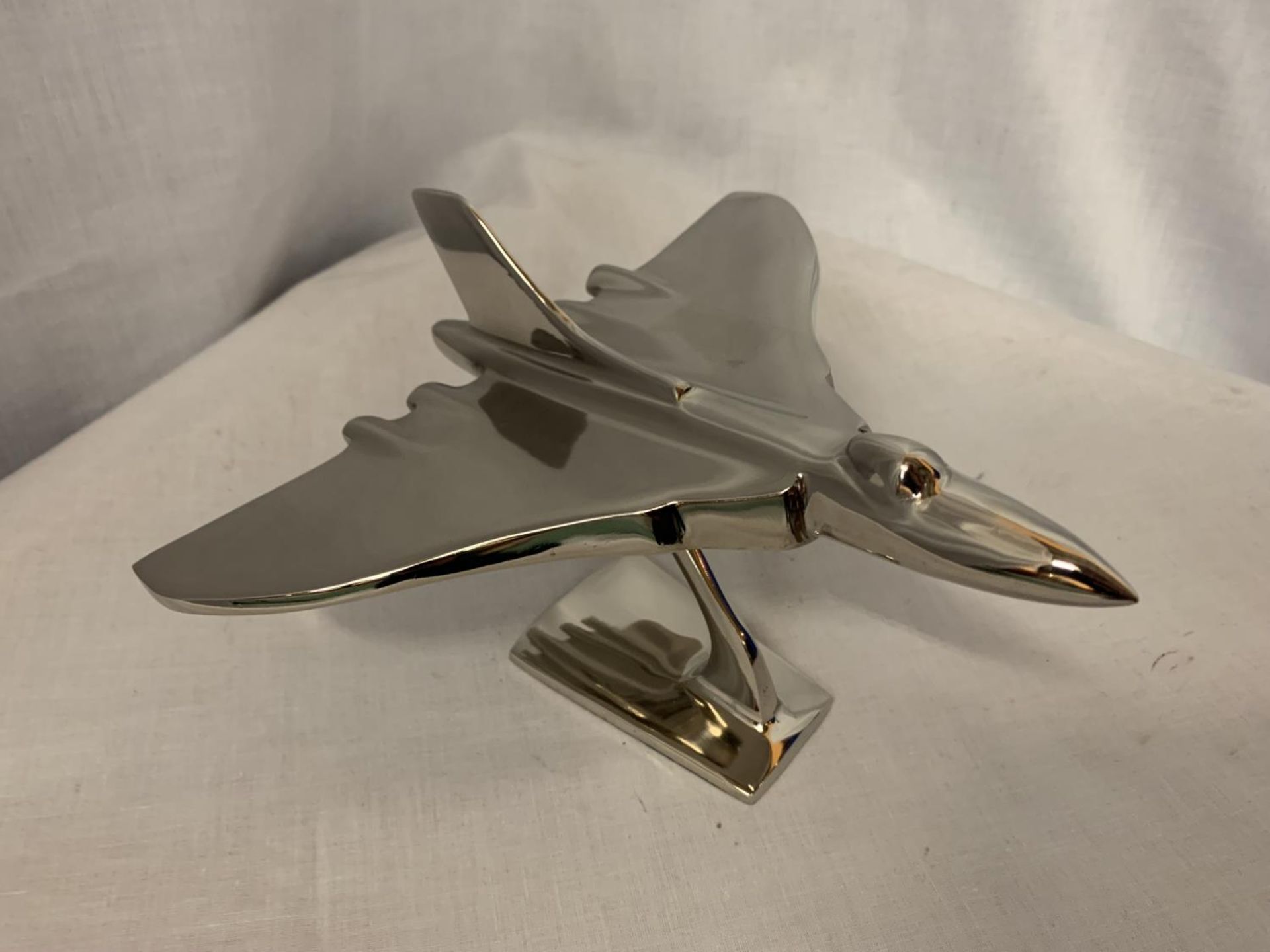 A CHROME MODEL OF AN AVRO VULCAN BOMBER ON STAND