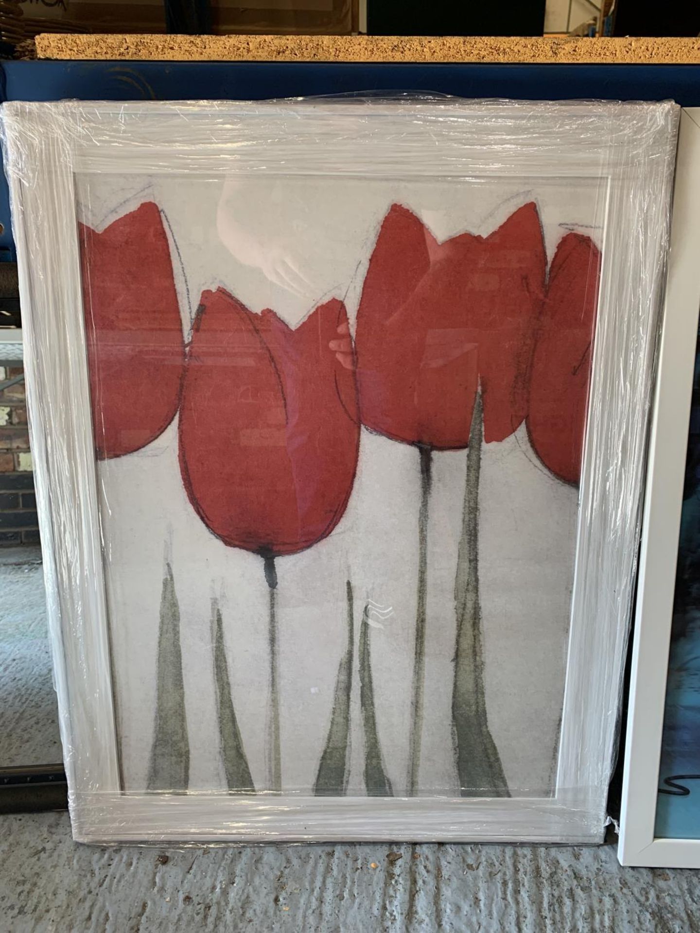 A WHITE FRAMED PICTURE OF RED TULIPS