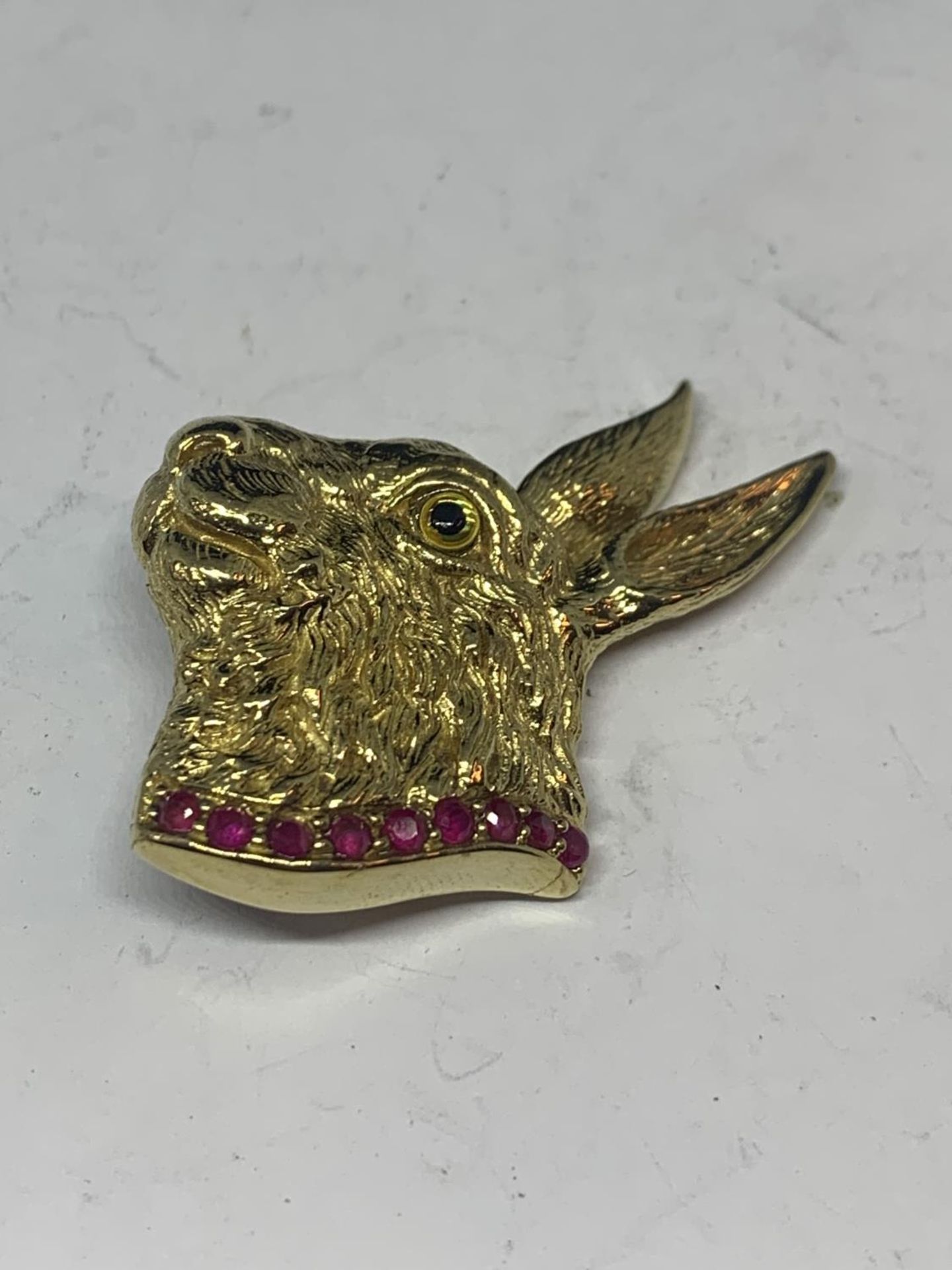 A SILVER GILT PENDANT IN THE FORM OF A HARE WITH A PINK STONE COLLAR