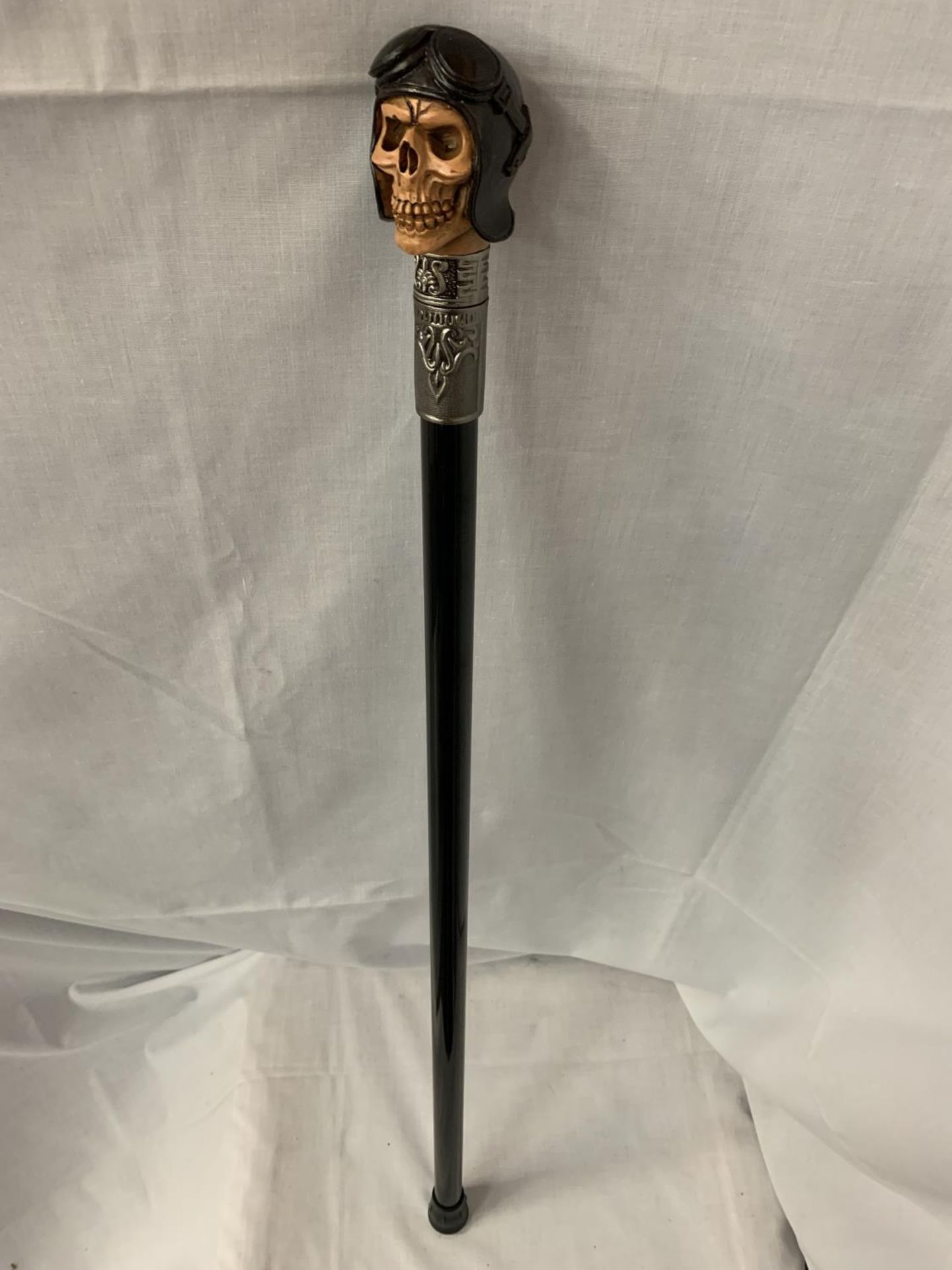 A WALKING STICK WITH A STEAMPUNK STYLE SKULL HEAD HANDLE