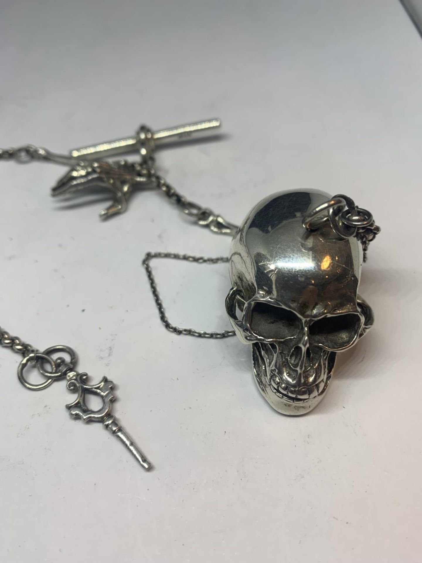 A HEAVY SILVER ALBERT CHAIN WITH LARGE SKULL FOB AND BONE, HAND ETC DESIGN - Image 8 of 10