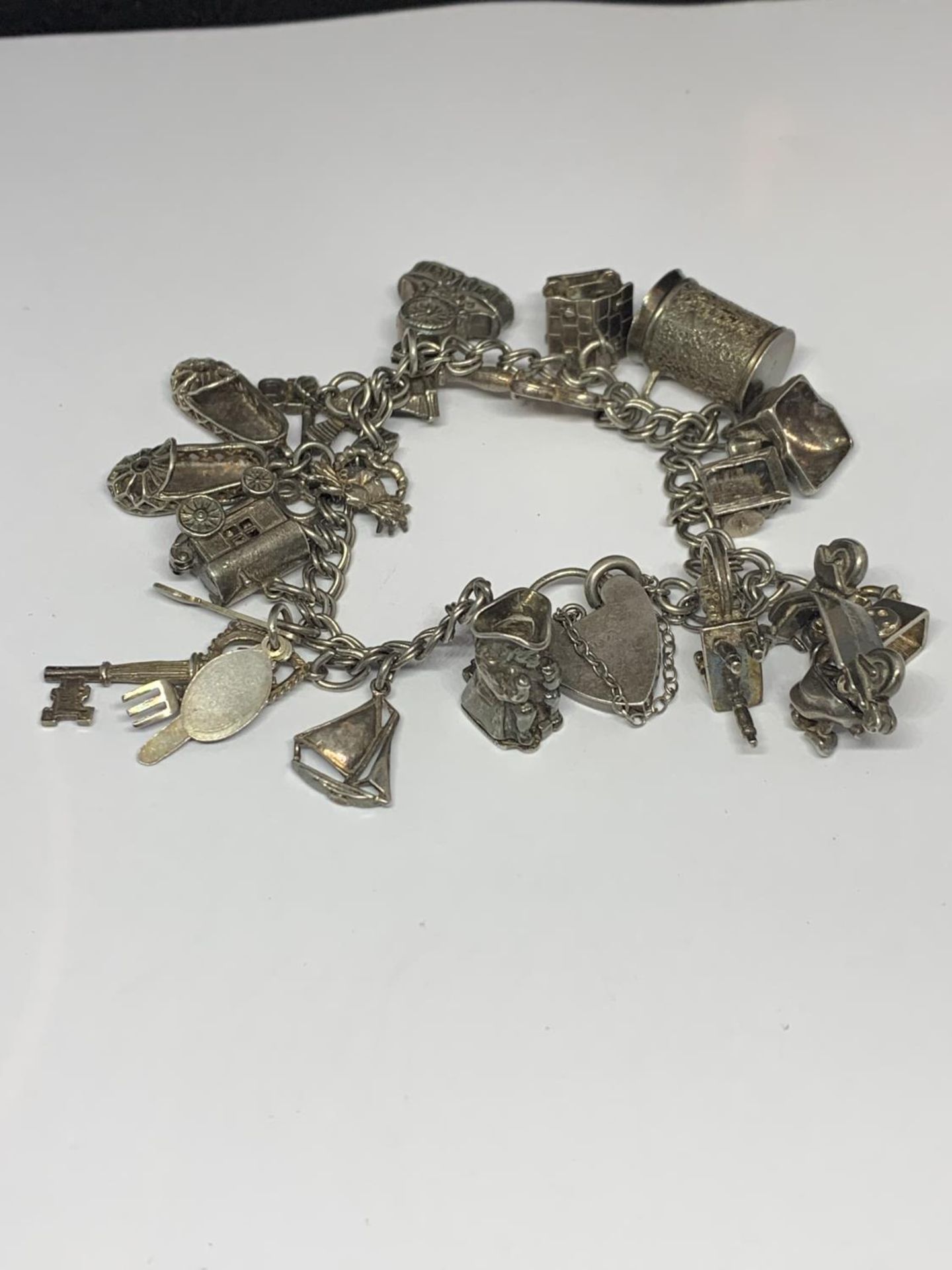 A SILVER CHARM BRACELET WITH EIGHTEEN CHARMS