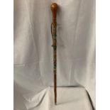 A WOODEN WALKING CANE WITH METAL TIP, LEATHER STRAP AND VARIOUS BADGES FROM THE ALPS