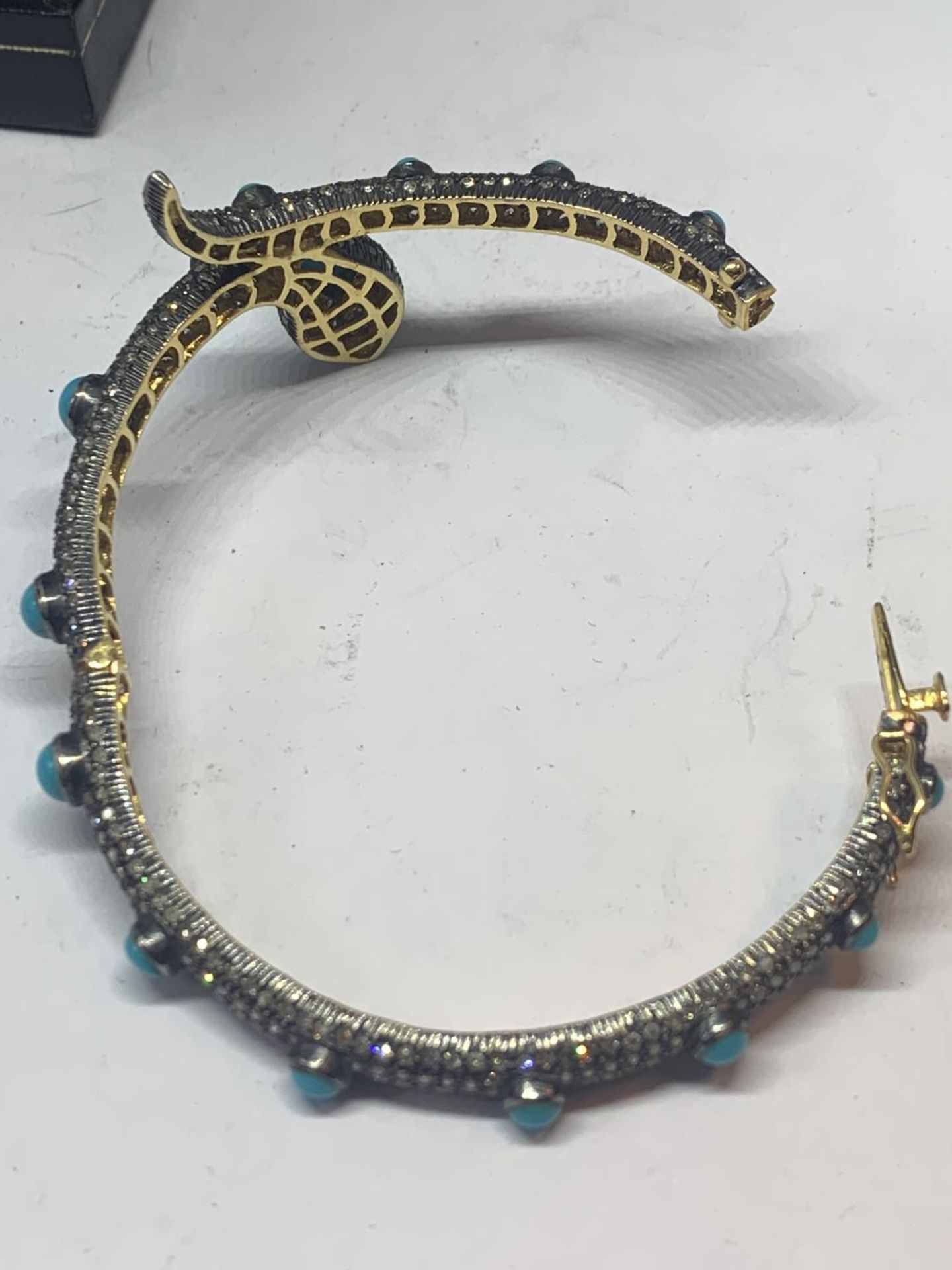 A GOLD AND WHITE GOLD SNAKE BANGLE ENCRUSTED WITH DIAMONDS, RUBY EYES AND BLUE NAJAVO STONES - Image 10 of 10