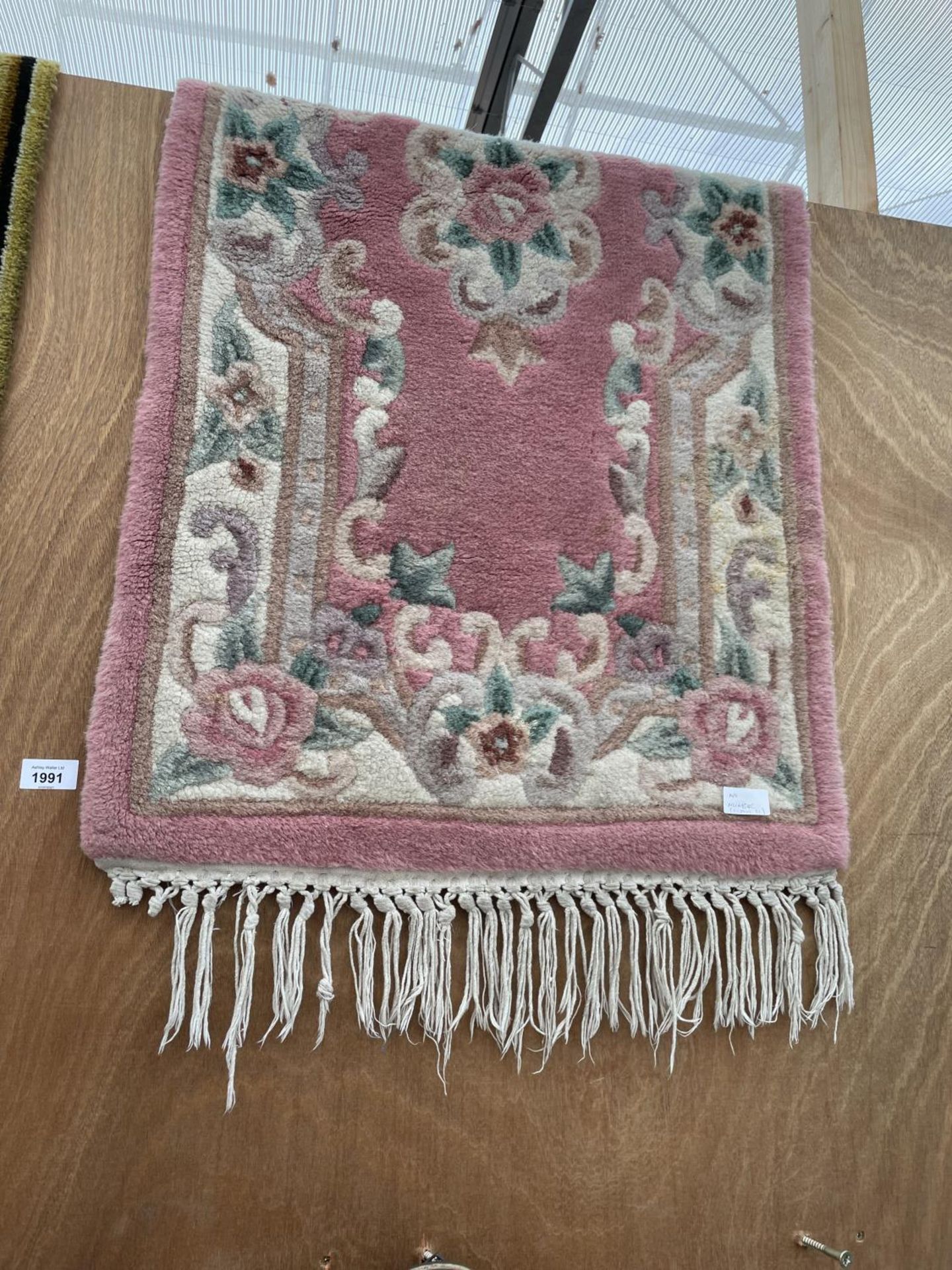A SMALL PINK PATTERNED RUG