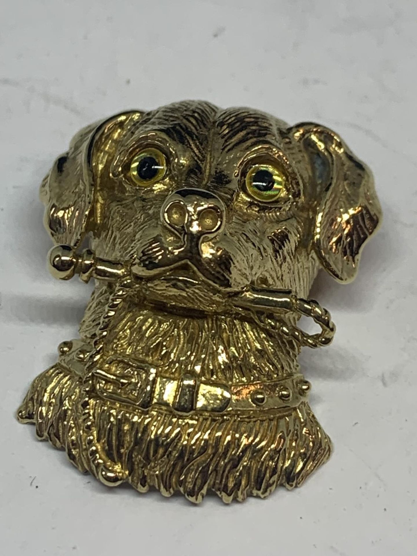 A SILVER GILT PENDANT IN THE FORM OF A DOG WITH GLASS EYES