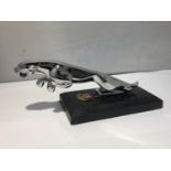 A CHROME JAGUAR CAR MASCOT ON MARBLE BASE