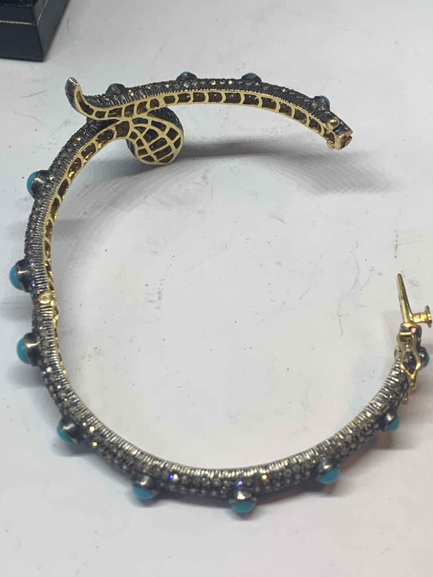A GOLD AND WHITE GOLD SNAKE BANGLE ENCRUSTED WITH DIAMONDS, RUBY EYES AND BLUE NAJAVO STONES - Image 9 of 10