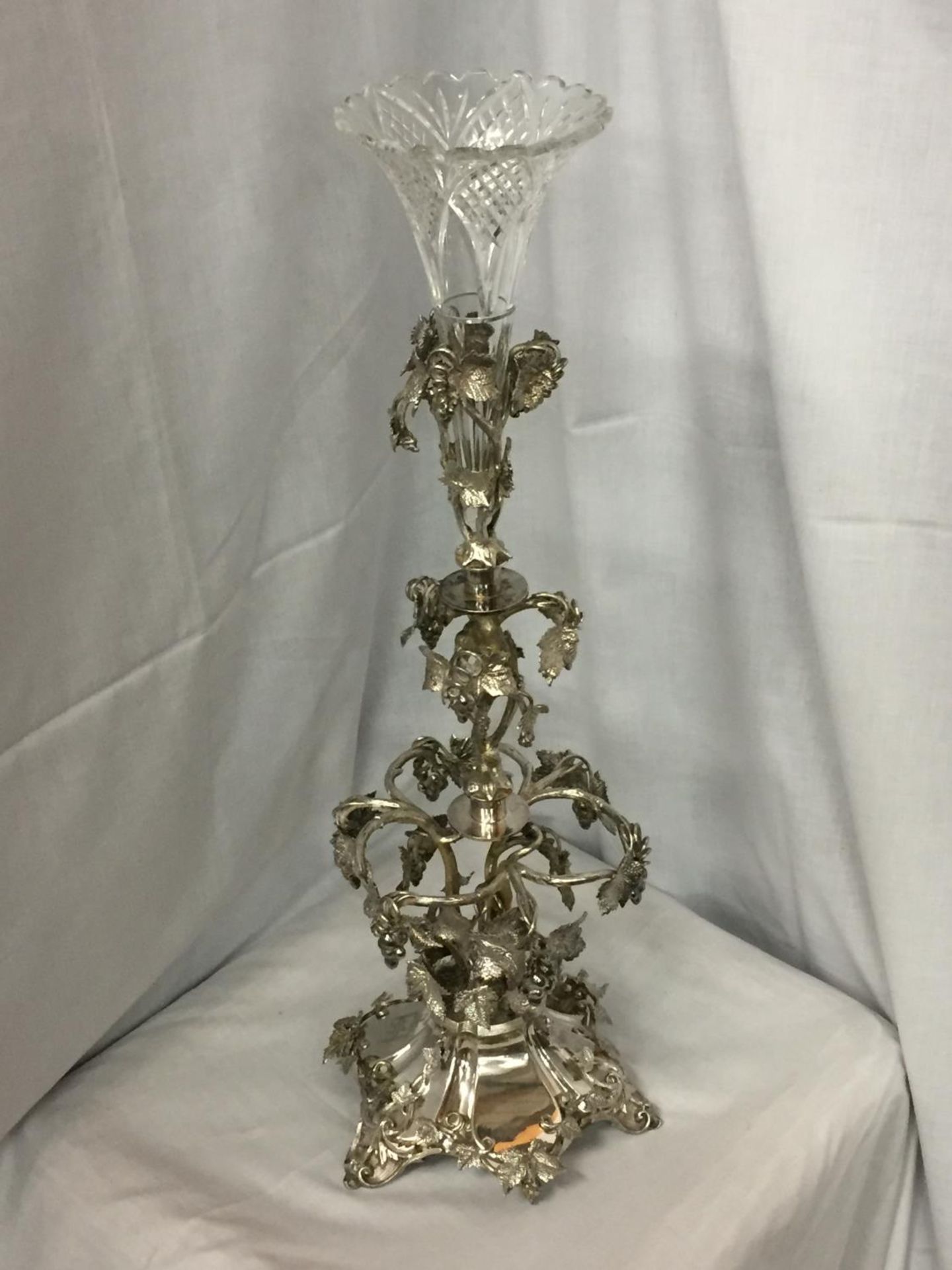 AN ORNATE SILVER PLATED EPERGENE WITH GLASS FLUTE HEIGHT 65CM