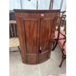 A GEORGE III MAHOGANY AND INLAID TWO DOOR BOWFRONTED CORNER CUPBOARD WITH INTERNAL DRAWERS AND