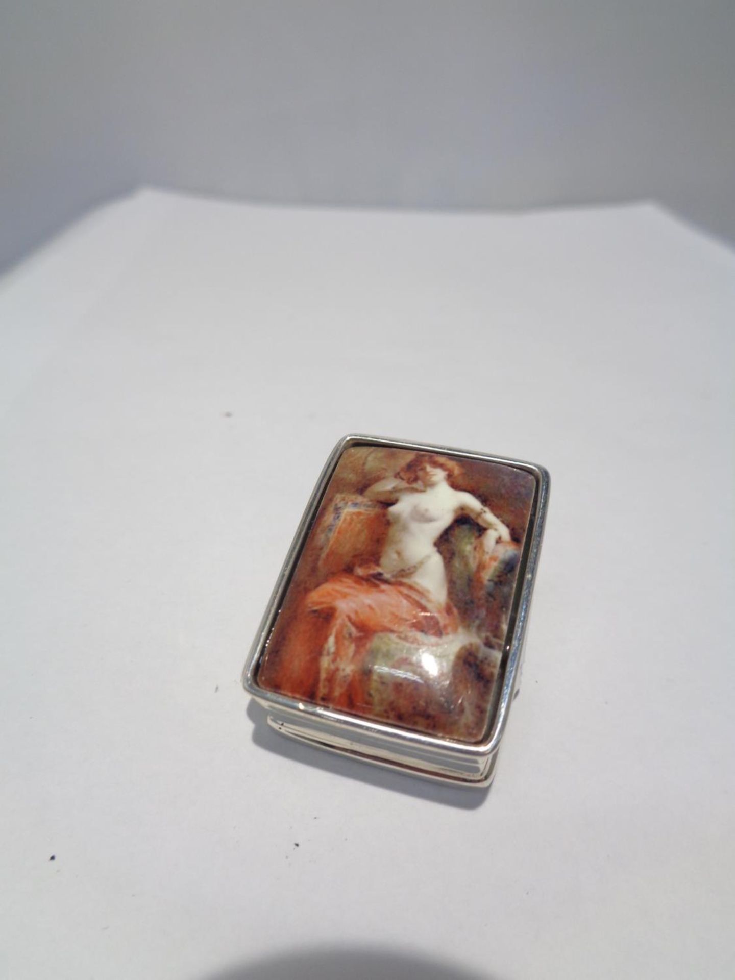 A MARKED SILVER PILL BOX WITH AN ENAMEL EROTIC DESIGN TOP