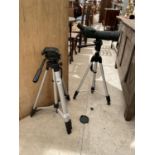 A TELESCOPE AND THREE TRIPOD CAMERA STANDS