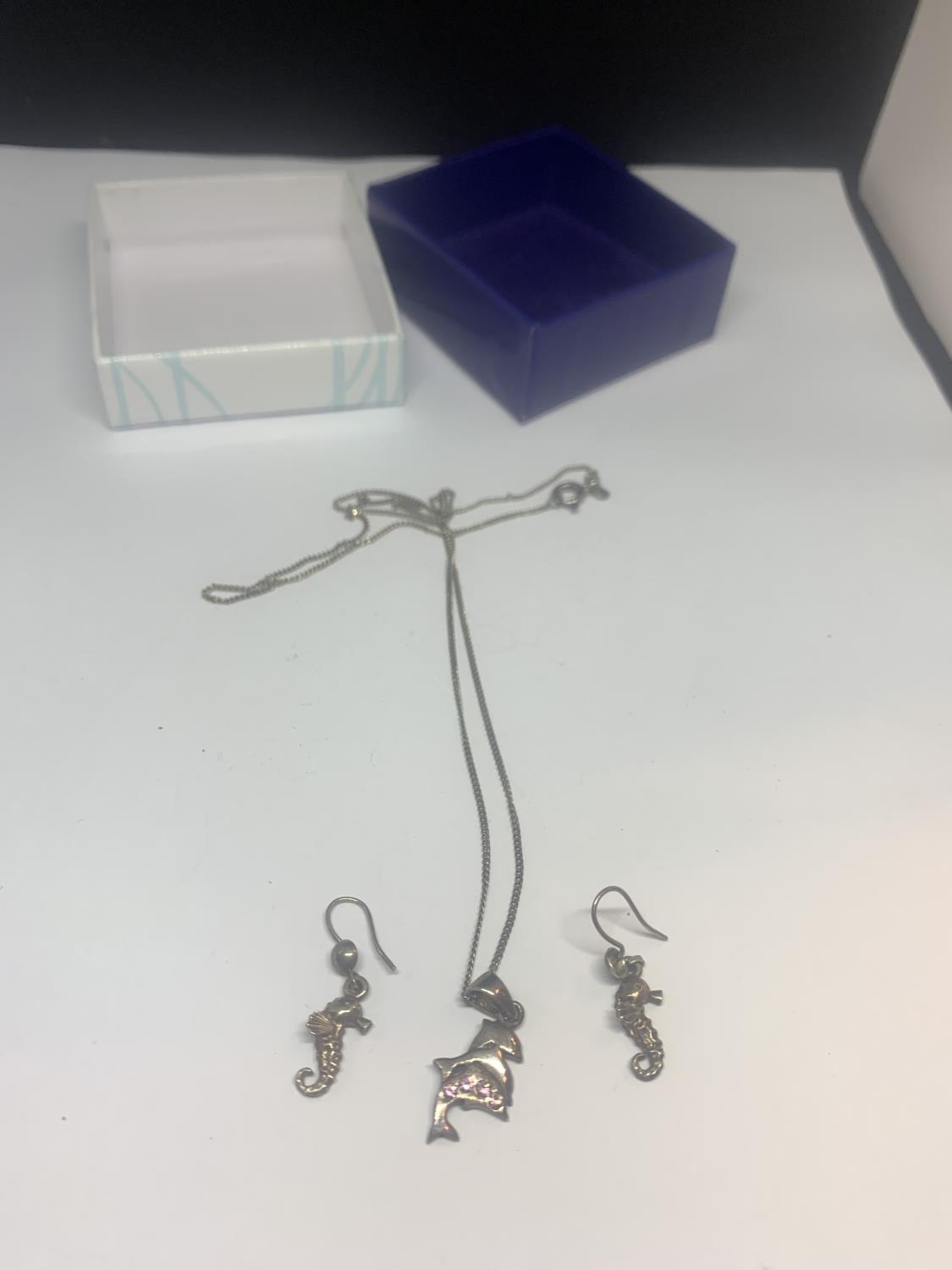 A SILVER NECKLACE WITH A DOLPHIN PENDANT AND A PAIR OF SEAHORSE EARRINGS WITH A PRESENTATION BOX