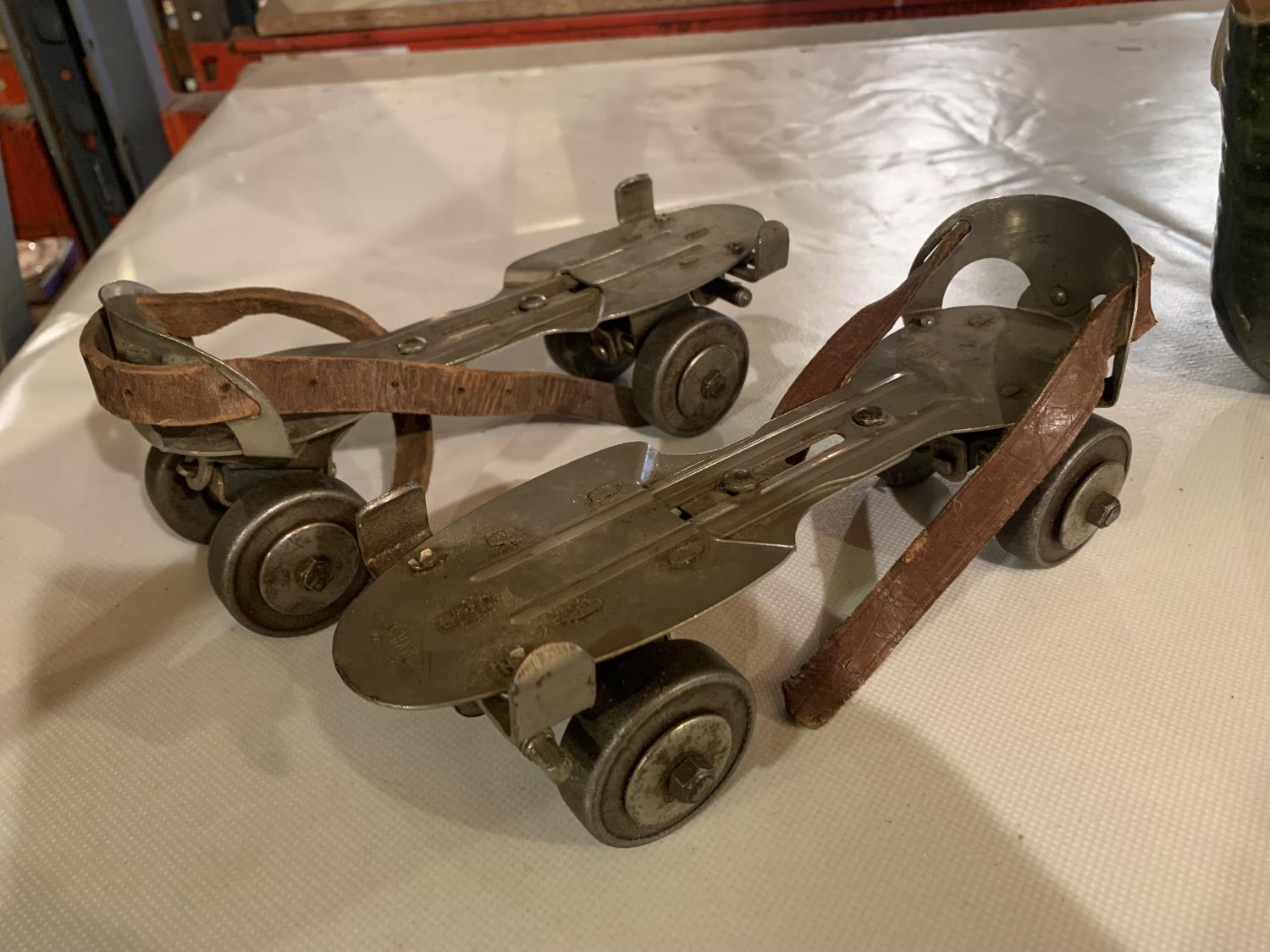 A PAIR OF DAVIES ADJUSTABLE ROLLER SKATES WITH LEATHER STRAPS