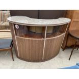 A 1970'S KIDNEY SHAPED BAR, 56" WIDE, WITH GLAZED UPPER PORTION AND SHAPED SLIDING DOORS
