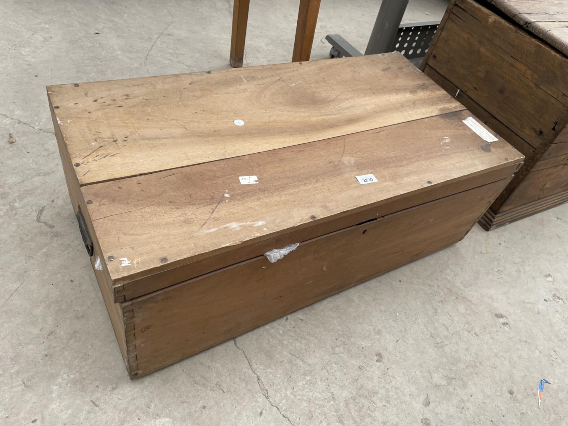 A HARDWOOD TRUNK WITH METALWARE CARRYING HANDLE