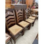 A SET OF FOUR OAK LADDERBACK DINING CHAIRS WITH RUSH SEATS