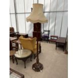 AN EARLY 20TH CENTURY STANDARD LAMP COMPLETE WITH SHADE, ON TURNED TAPERED COLUMN WITH PINEAPPLE