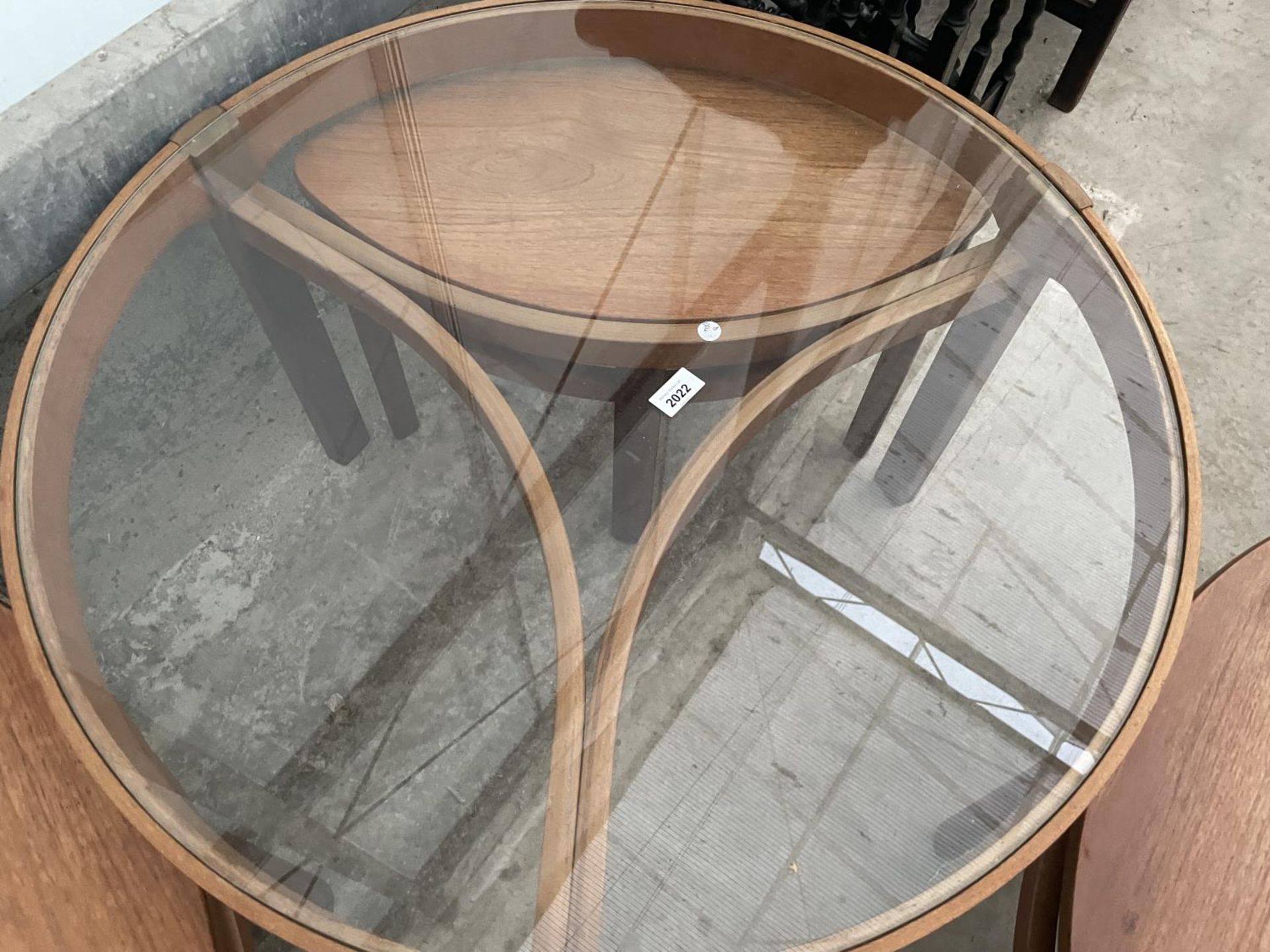 A RETRO TEAK CIRCULAR NEST OF FOUR TABLES WITH GLASS TOP AND THREE UNDER TABLES, OVAL IN SHAPE, - Image 7 of 7