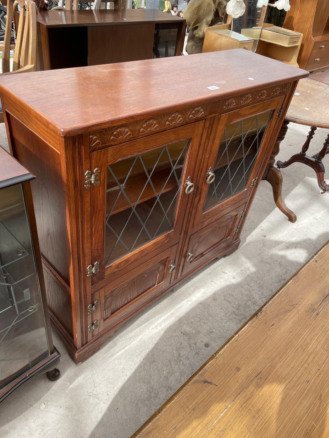 A STANLEY WOOD OAK GLAZED AND LEADED BOOKCASE WITH CUPBOARDS TO THE BASE, 42" WIDE