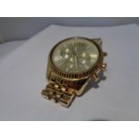 A GILT CHRONOGRAPH FASHION WATCH SEEN WORKING BUT NO WARRANTY