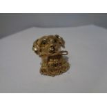 A SILVER GILT PENDANT IN THE FORM OF A DOG WITH GLASS EYES