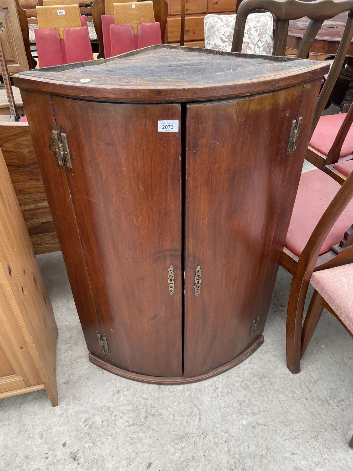 A GEORGE III MAHOGANY TWO DOOR BOWFRONTED CORNER CUPBOARD