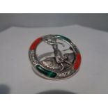 A MARKED SILVER BROOCH WITH GREEN AND RED STONES DEPICTING A LADY GOLFER