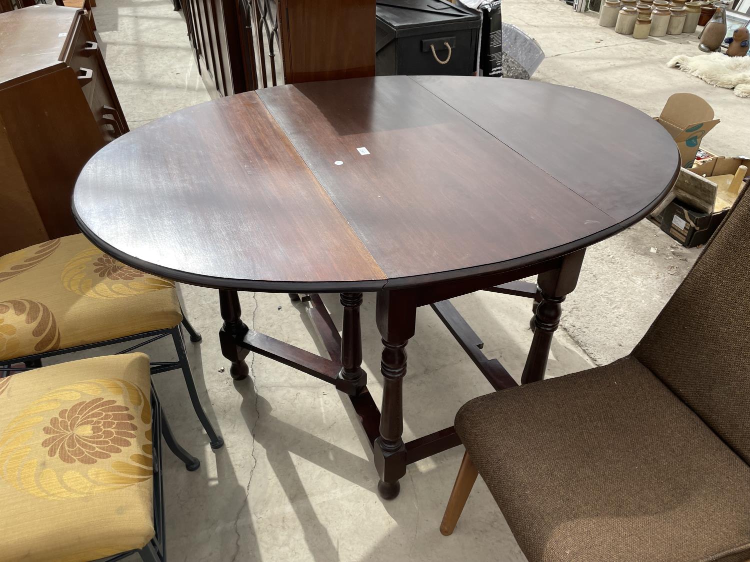 A MAHOGANY OVAL GATELEG DINING TABLE ON TURNED LEGS