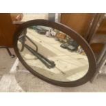 A WOODEN FRAMED OVAL MIRROR