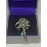 A SILVER RING WITH BLUE STONE AND FEATHER IN A PRESENTATION BOX