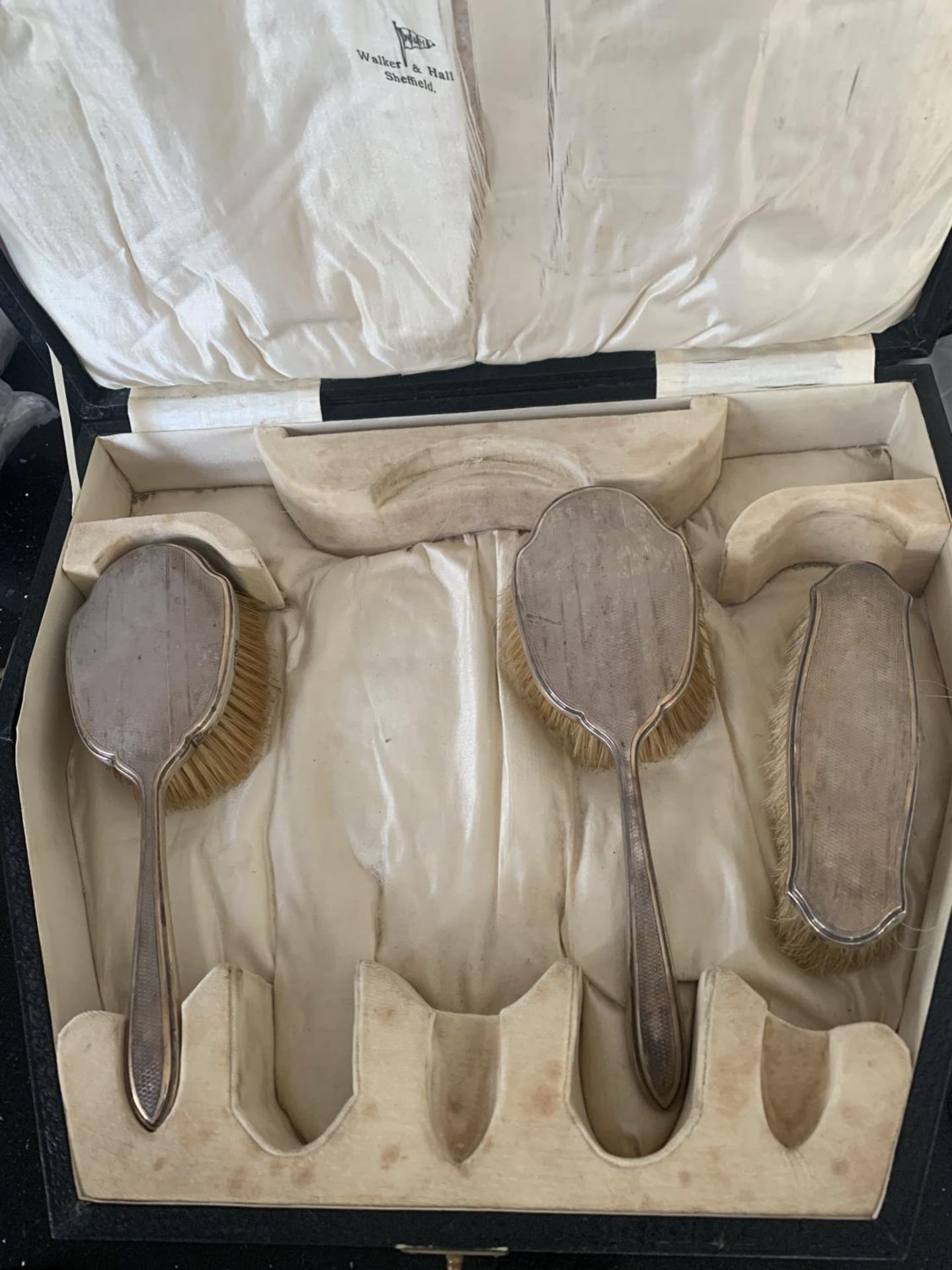 THREE HALLMARKED SHEFFILED SILVER BACKED BRUSHES IN A PRESENTATION BOX