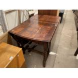 AN OVAL OAK DROP LEAF DINING TABLE ON BARLEY TWIST SUPPORTS