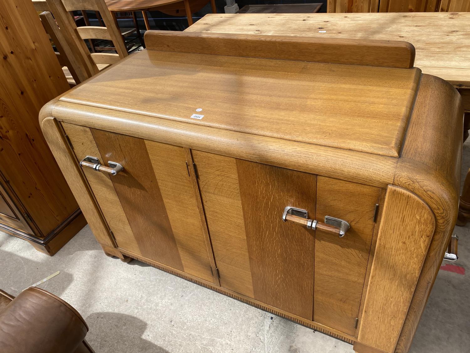 AN OAK E-GOMME SIDEBOARD DATED 1939 ENCLOSING CURVED END CUPBOARDS, TWO PAIRS OF CUPBOARDS WITH FOUR