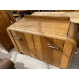 AN OAK E-GOMME SIDEBOARD DATED 1939 ENCLOSING CURVED END CUPBOARDS, TWO PAIRS OF CUPBOARDS WITH FOUR