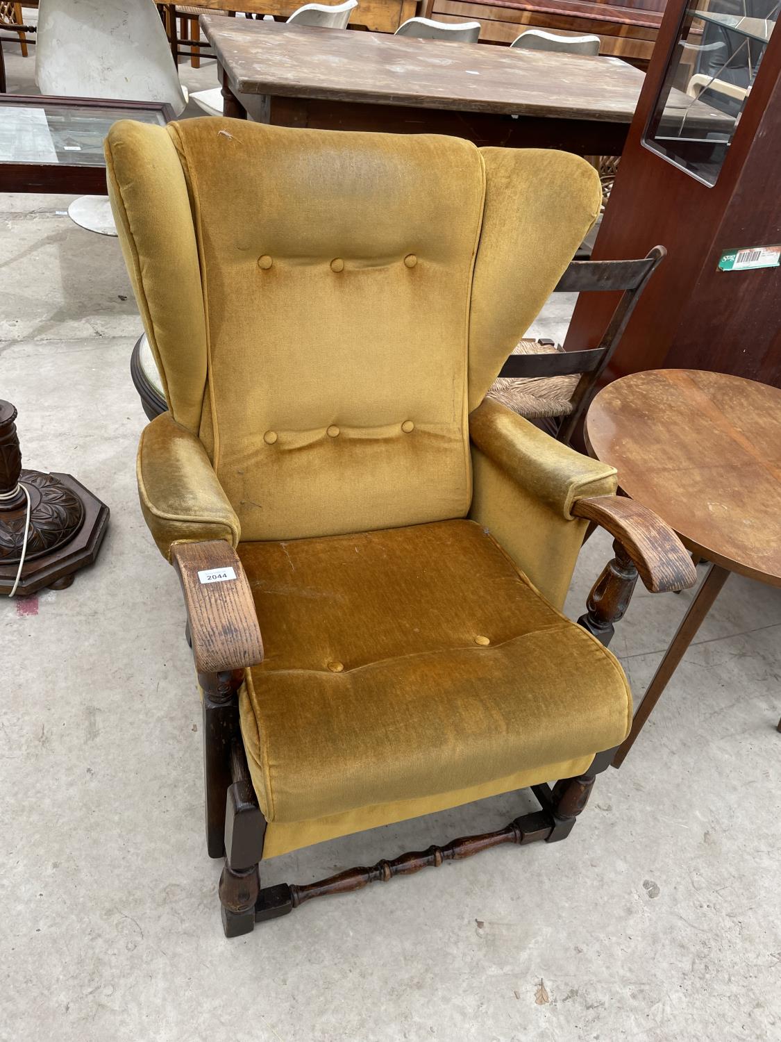 A MID 20TH CENTURY OAK FRAMED WINGED FIRESIDE CHAIR