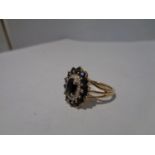 A 9 CARAT GOLD CLUSTER RING WITH A CENTRE SAPPHIRE AND SURROUNDING DIAMONDS AND SAPPHIRES SIZE 0