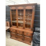 AN OAK OLD CHARM GLAZED AND LEADED CABINET ON BASE ENCLOSING THREE DRAWERS AND THREE CUPBOARDS, 52.