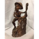 AN INTRICATELY CARVED AFRICAN TRIBAL FIGURE OF A FISHERMAN CASTING HIS NET, HEIGHT 42 CM