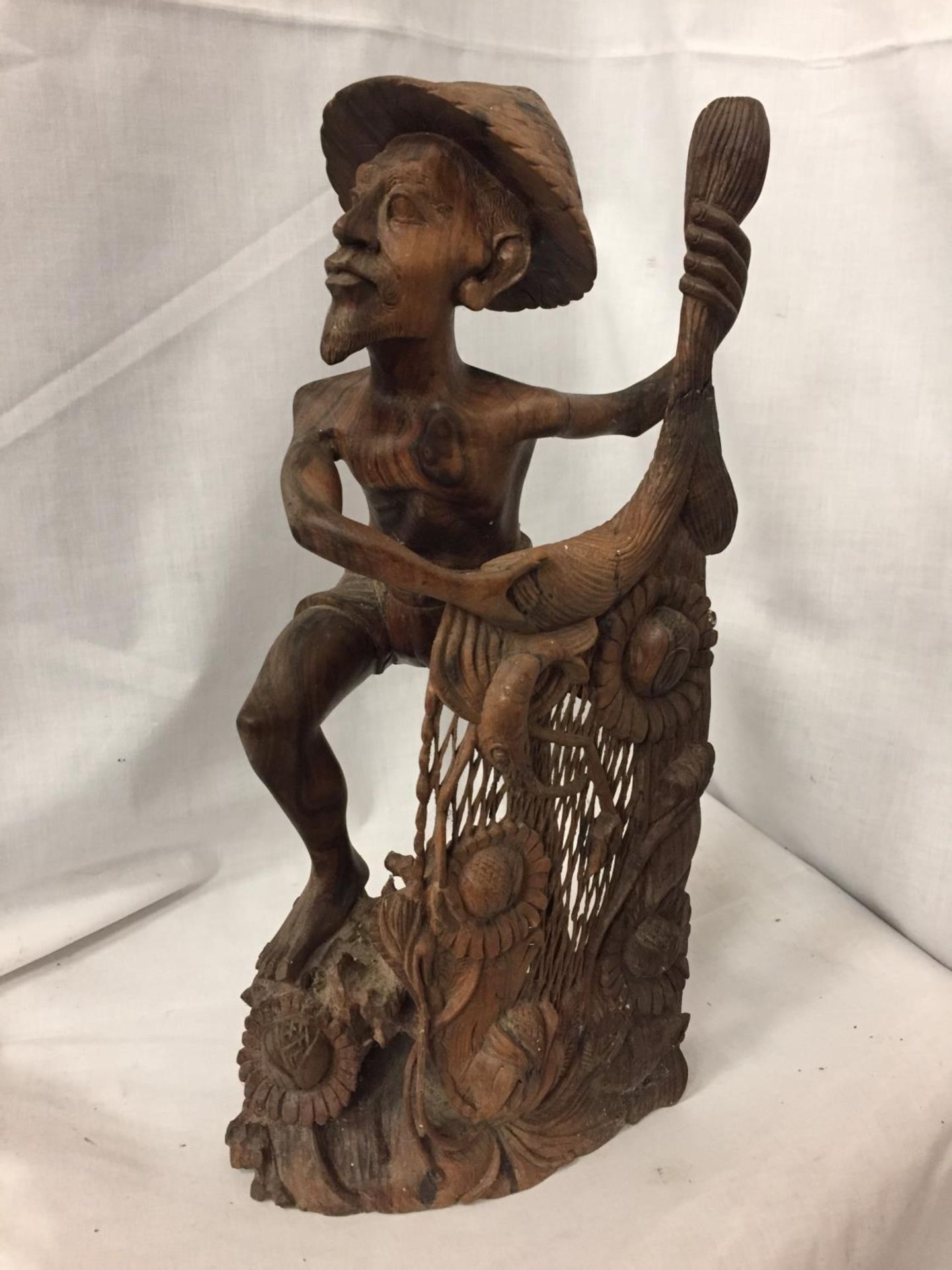 AN INTRICATELY CARVED AFRICAN TRIBAL FIGURE OF A FISHERMAN CASTING HIS NET, HEIGHT 42 CM